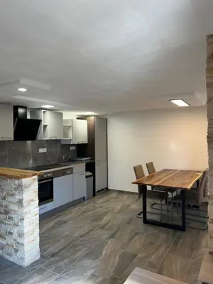 a large kitchen with a wooden table and a dining room at Apartma Ročica Dejan Uršič sobodajalec in Kobarid