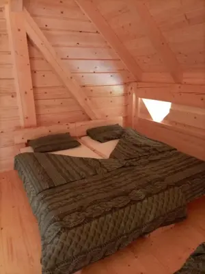a room with a bed in a log cabin at Kamp Beli gaber in Stari Trg pri Ložu