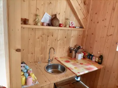 a kitchen with a sink in a wooden cabin at Kamp Beli gaber in Stari Trg pri Ložu
