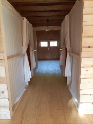 an empty room with white curtains and a wooden floor at Kamp Beli gaber in Stari Trg pri Ložu