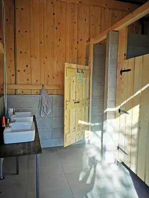 a bathroom with a sink and a wooden wall at Kamp Beli gaber in Stari Trg pri Ložu