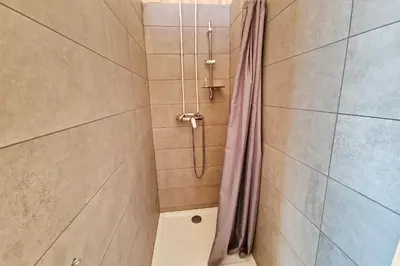 a shower with a shower curtain in a bathroom at Kamp Beli gaber in Stari Trg pri Ložu
