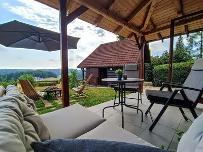 a patio with a couch and an umbrella and a table at Chalet Panorama in Občine