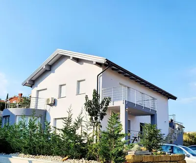 a white house with trees in front of it at Villa Ines in Zgornje Škofije