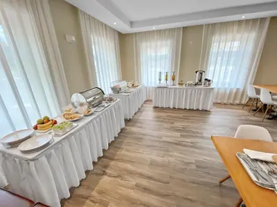 a row of tables with food on them in a room at TOSCANINA Garni Hotel in Dobrovo