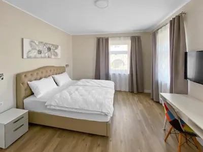 a bedroom with a bed and a desk and a television at TOSCANINA Garni Hotel in Dobrovo