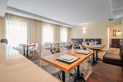 a dining room with tables and chairs at TOSCANINA Garni Hotel in Dobrovo