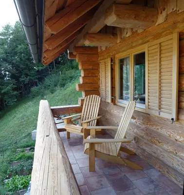 two chairs sitting on the porch of a log cabin at Natur apartma Rudi in Begunje na Gorenjskem