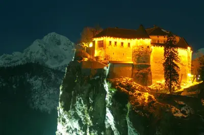 a building on the side of a mountain at night at Fantastic Apartment Brglez in Bohinjska Bela