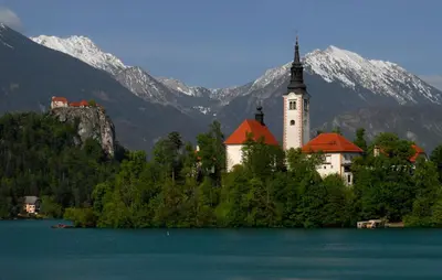 a church on an island in the middle of a lake at Fantastic Apartment Brglez in Bohinjska Bela