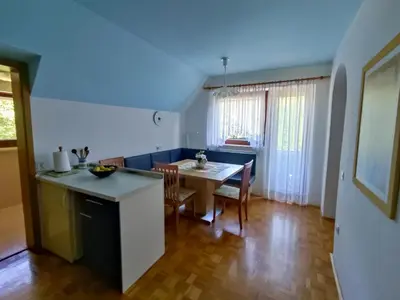 a kitchen and living room with a table and chairs at Fantastic Apartment Brglez in Bohinjska Bela