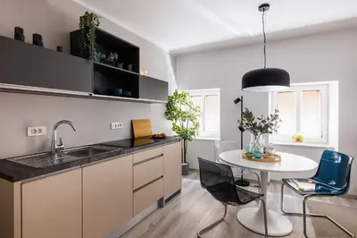 a kitchen with a sink and a table with chairs at New Central Studios with parking in Ljubljana