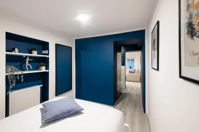 a bedroom with blue walls and a white bed at New Central Studios with parking in Ljubljana