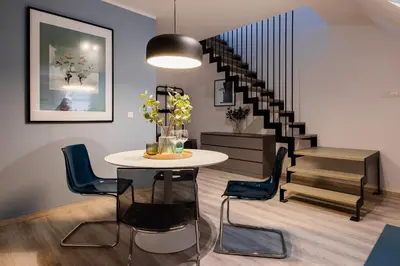 a room with a table and chairs and a staircase at New Central Studios with parking in Ljubljana