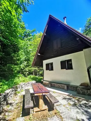 a picnic table in front of a building at Koča Kresnica in Ilirska Bistrica