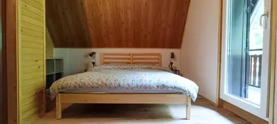 a bedroom with a bed with a wooden headboard at Koča Kresnica in Ilirska Bistrica