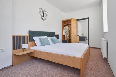 a bedroom with a bed with a wooden headboard at Ob Krki Apartments and GYM in Kostanjevica na Krki