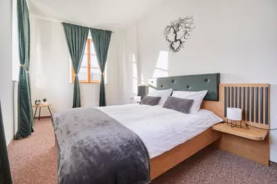 a bedroom with a large bed with white sheets and pillows at Ob Krki Apartments and GYM in Kostanjevica na Krki