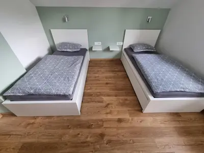 two beds sitting in a room with wooden floors at Apartment 199 in Zgornje Gorje