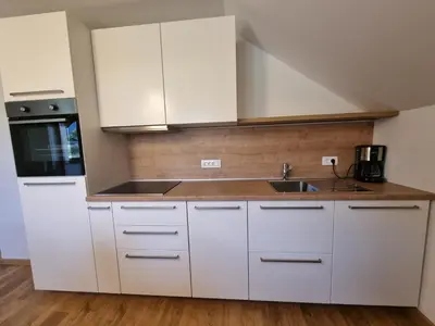 a kitchen with white cabinets and a sink at Apartment 199 in Zgornje Gorje