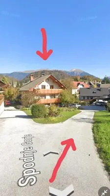 a street sign with two arrows on the road at Apartment 199 in Zgornje Gorje