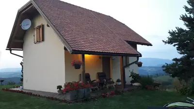 a small white house with a brown roof at Holiday House PANORAMA in Podčetrtek