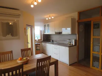 a kitchen with a table with a bowl of fruit on it at Holiday House PANORAMA in Podčetrtek