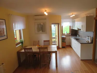 a kitchen with a wooden table and chairs in a kitchen at Holiday House PANORAMA in Podčetrtek