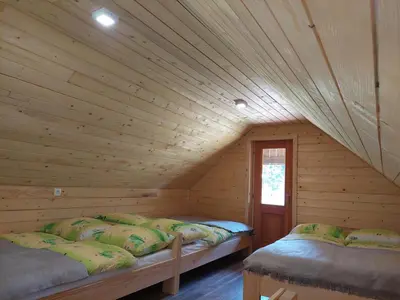 a room with two beds in a log cabin at Hut Vaznik in Mrzli Studenec