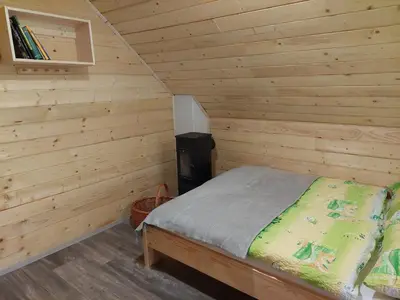 a bedroom with a bed in a wooden cabin at Hut Vaznik in Mrzli Studenec