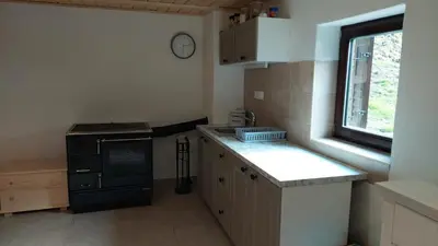 a small kitchen with a sink and a stove at Hut Vaznik in Mrzli Studenec
