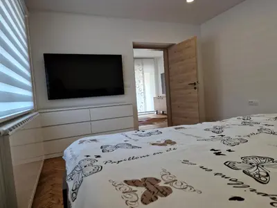 a bedroom with a bed and a flat screen tv at Apartmaji PR' KERIN in Laško