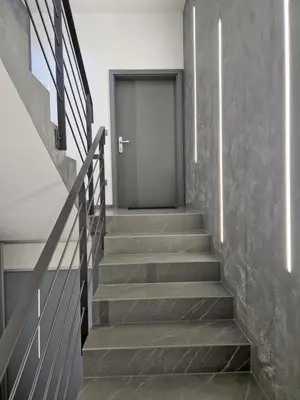 a hallway with stairs leading to a door at Apartmaji PR' KERIN in Laško