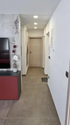 a hallway with a door and a vase of flowers at Apartmaji PR' KERIN in Laško