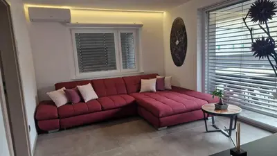 a red couch in a living room with a window at Apartmaji PR' KERIN in Laško