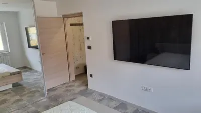 a living room with a large television on a wall at Apartmaji PR' KERIN in Laško