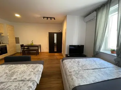 a bedroom with two beds and a dining room with a table at Ljubljana Studios in Ljubljana