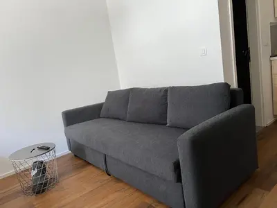 a gray couch in a living room with a table at Ljubljana Studios in Ljubljana