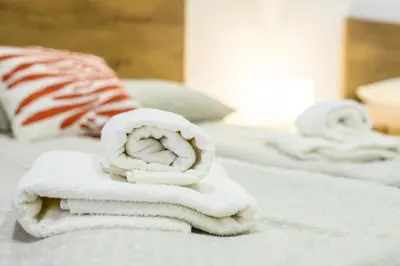 a pile of towels sitting on top of a bed at The Comfortable Loft in Ljubljana