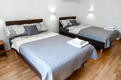 a bedroom with two beds and a night stand at Sobe in apartmaji Bama in Litija