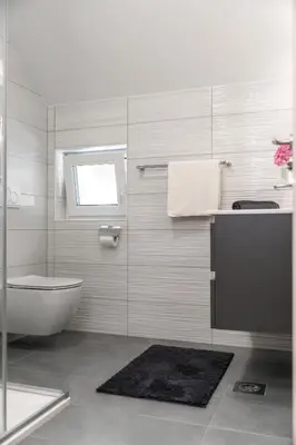 a bathroom with a tub and a toilet and a sink at Sobe in apartmaji Bama in Litija