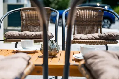 a table with two chairs and two cups on it at Sobe in apartmaji Bama in Litija