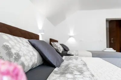 a bedroom with a bed with pillows and a couch at Sobe in apartmaji Bama in Litija