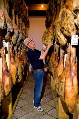a man standing next to a display of meat at Belica Bed and Breakfast in Dobrovo