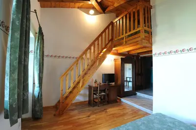 a wooden staircase in a room with a desk at Belica Bed and Breakfast in Dobrovo