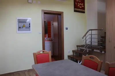 a room with a table and chairs and a staircase at Charming countryside house in Lome