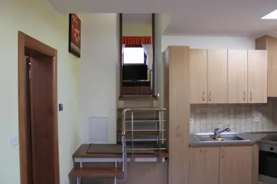 a kitchen with wooden cabinets and a sink at Charming countryside house in Lome