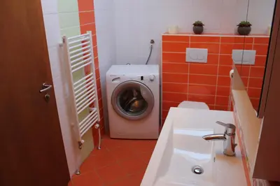 a bathroom with a washing machine and a sink at Charming countryside house in Lome