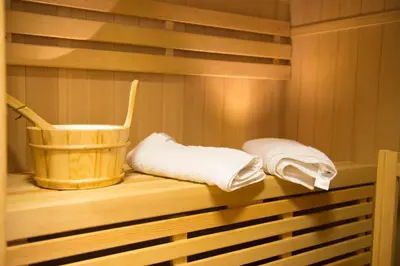 a sauna with two towels and a bucket on a shelf at Cottage House Jakob in Cerklje na Gorenjskem