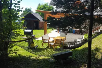 a hammock in the yard of a house at Cottage House Jakob in Cerklje na Gorenjskem